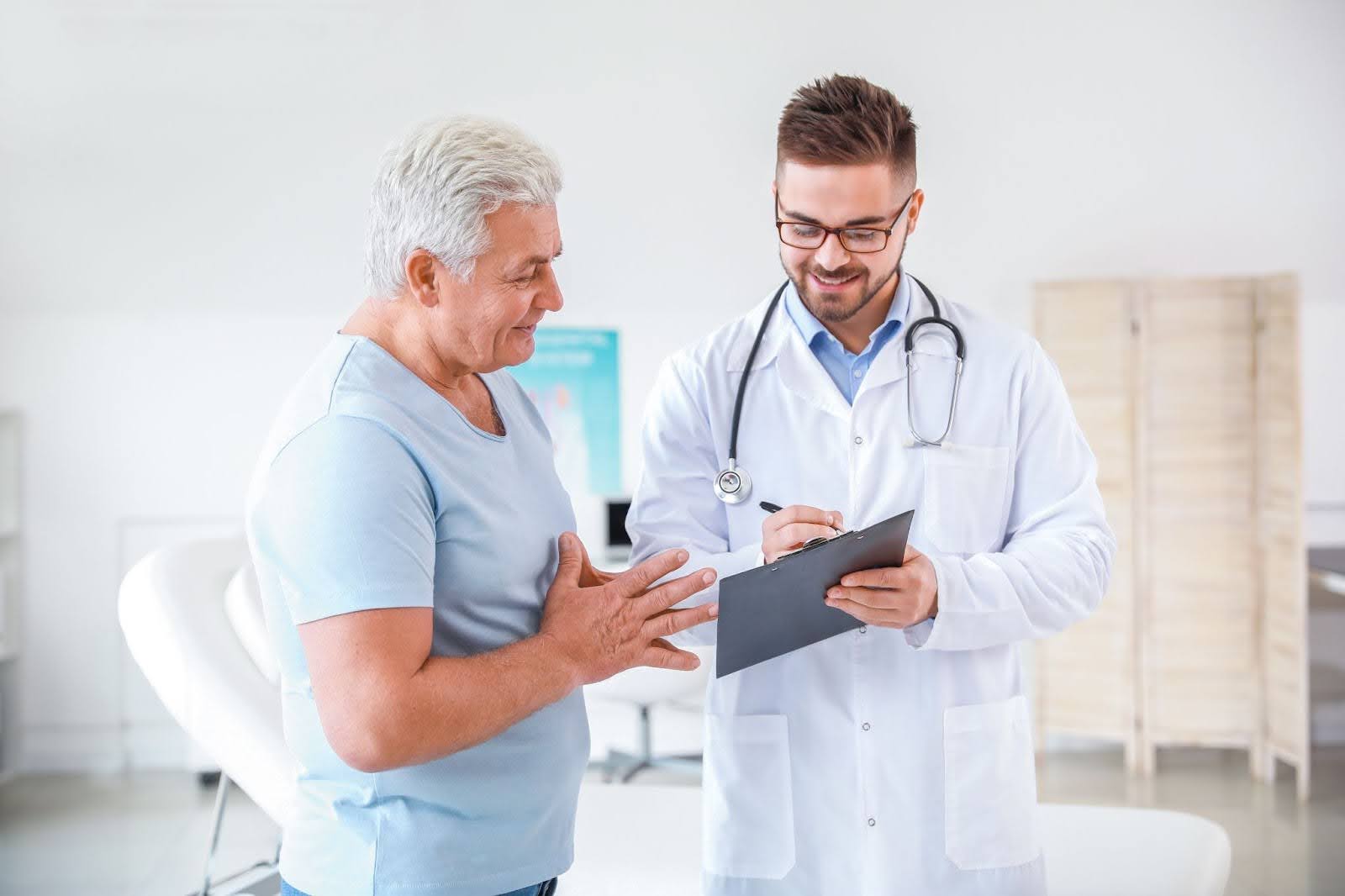 Male doctor explaining the connection between prostate and constipation.