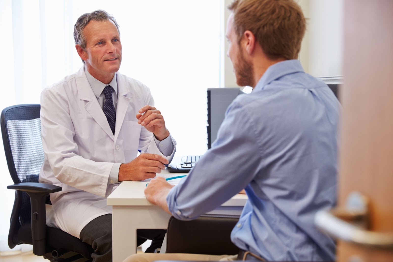 Man discussing with doctor how often he should get a prostate exam.